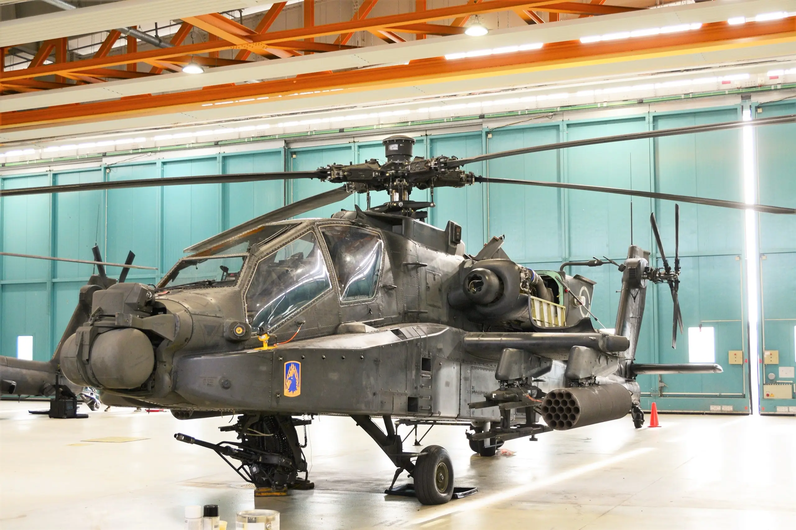 AH-64D Apache Longbow in a maintenance hangar, its round Longbow radar dome above the rotor